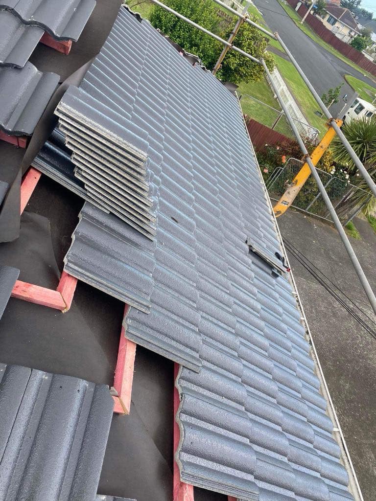 A finished long-run roof with edge protection rails still up along the eaves