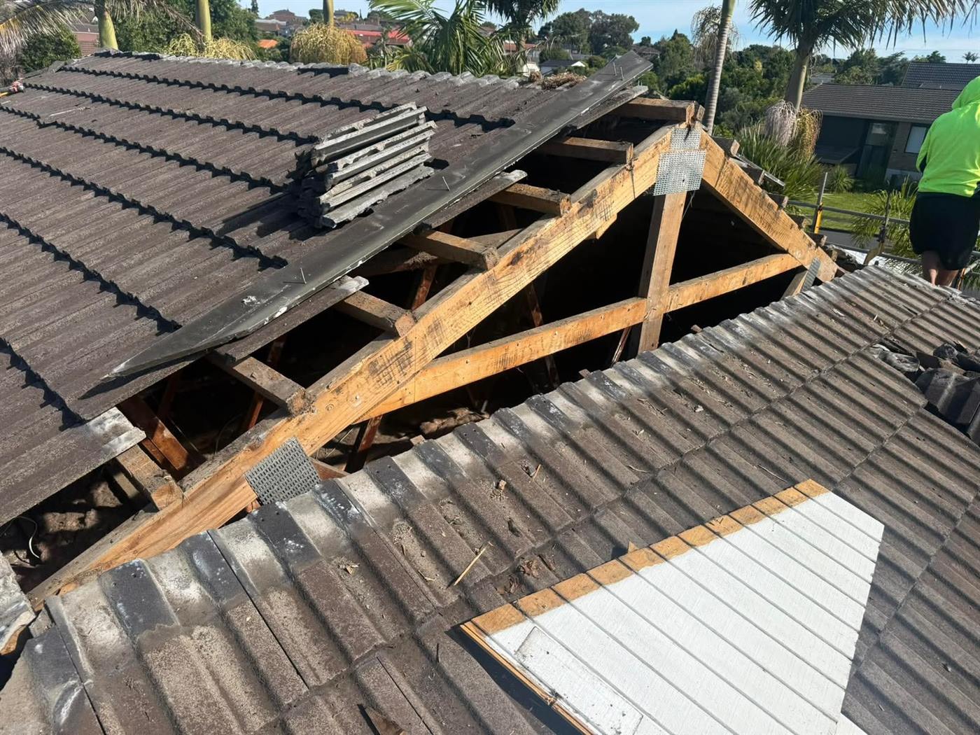 A tile roof opened up along a valley with the rafters exposed