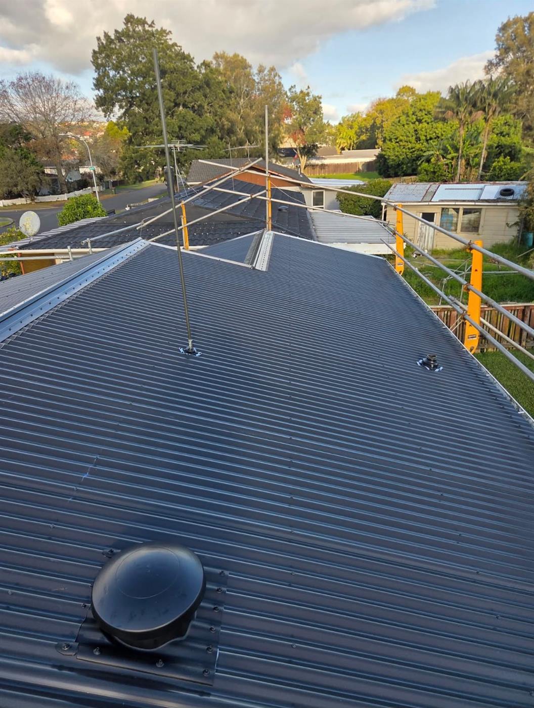 A roof vent seated into the new dark long-run roof