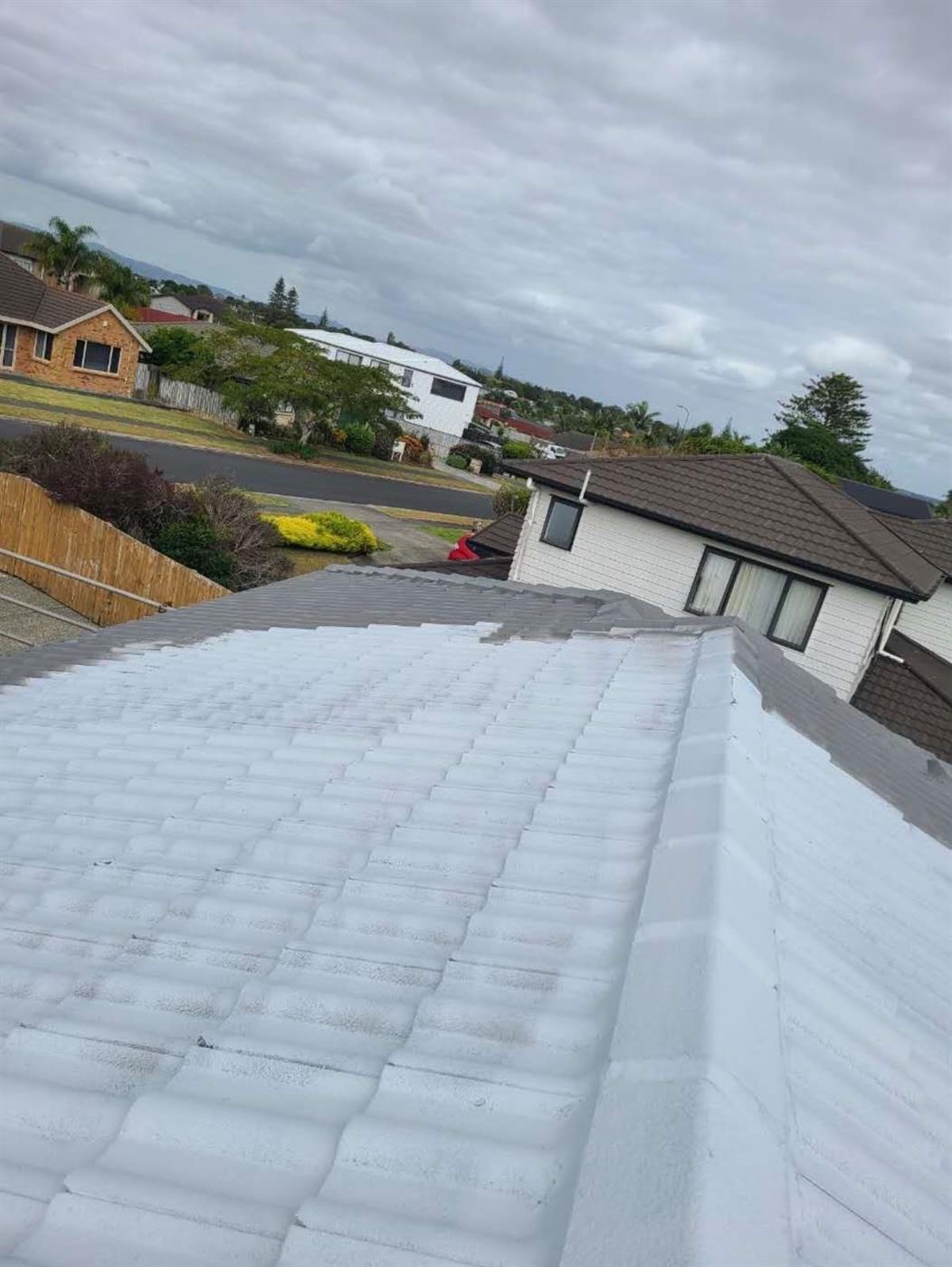 A finished restored concrete tile roof looking along the ridge toward the street